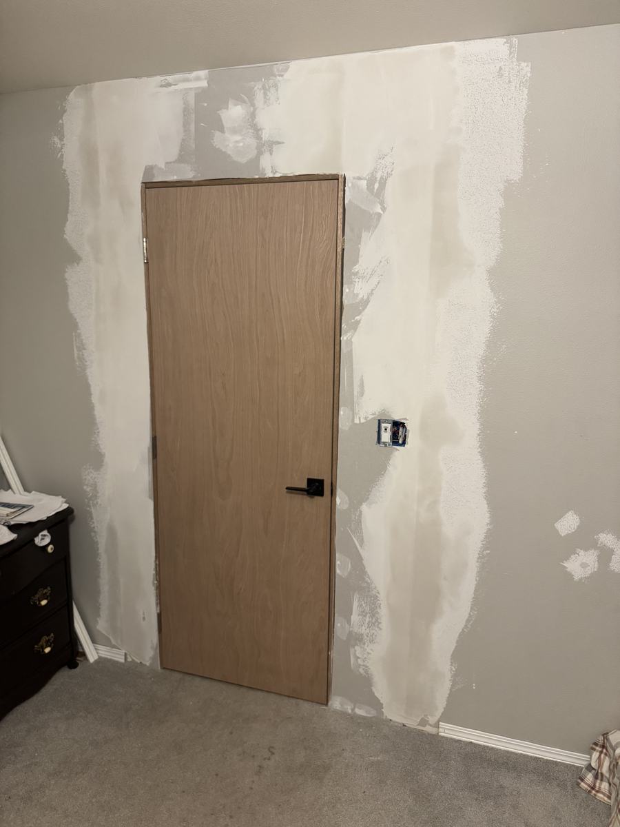 Before — drywall patched around new door opening, unfinished